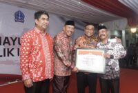 Bupati Bone Andi Fahsar M Padjalangi menyerahkan penghargaan kepada salah satu kepala desa mandiri. (ist)