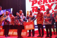 Gubernur Andi Sudirman Sulaiman menyerahkan piala juara 1 PPD Zona 3 Sulsel kepada Bupati Bone Andi Fahsar M Padjalangi. (ist)