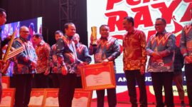 Gubernur Andi Sudirman Sulaiman menyerahkan piala juara 1 PPD Zona 3 Sulsel kepada Bupati Bone Andi Fahsar M Padjalangi. (ist)