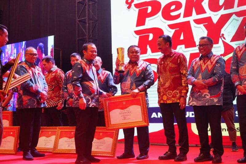 Gubernur Andi Sudirman Sulaiman menyerahkan piala juara 1 PPD Zona 3 Sulsel kepada Bupati Bone Andi Fahsar M Padjalangi. (ist)