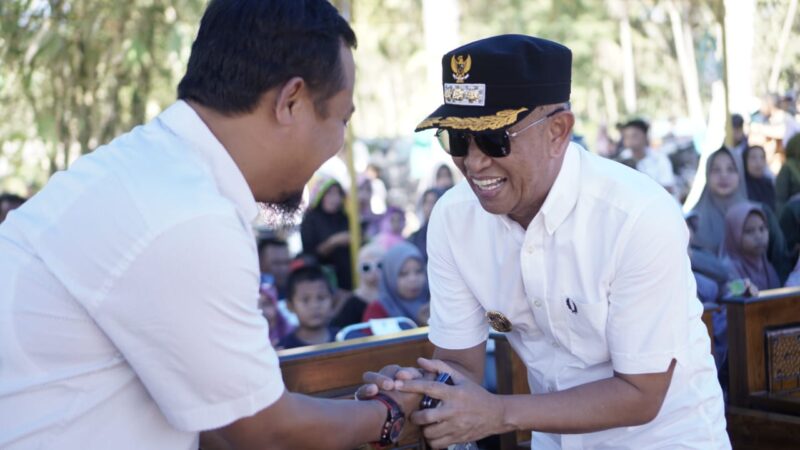 Pj Bupati Bone Andi Islamuddin (kacamata) bersalaman dengan Mantan Gubernur Sulsel Andi Sudirman Sulaiman di acara pesta rakyat Desa Corowali. (ist)