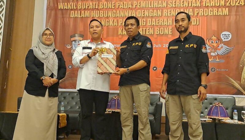 Kepala Bappeda Bone Ade Fariq Ashar (baju putih) menyerahkan dokumen teknokratik RPJMD kepada komisioner KPU Bone Zainal. (DIKSIKU/Idhul)