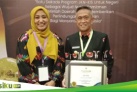 Pj Bupati Bone Andi Islamuddin saat menerima penghargaan UHC Award 2024. (ist)