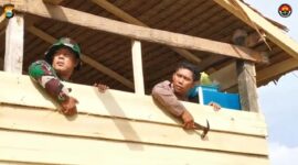 Bripka Andi Rusman dan Serda Darwis saat memasang dinding rumah untuk Nenek Daramang. (ist)