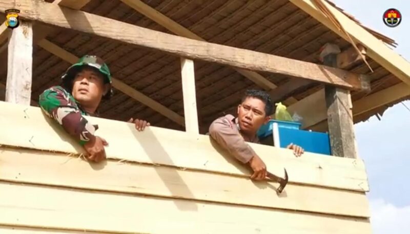 Bripka Andi Rusman dan Serda Darwis saat memasang dinding rumah untuk Nenek Daramang. (ist)