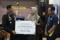 Kapolres Bone AKBP Erwin Syah serahkan secara simbolis santunan kepada istri almarhum AKP DIKSIKU.com, Bone - Suasana haru dan penghormatan menyelimuti Mapolres Bone ketika Kapolres Bone, AKBP Erwin Syah, bersama dengan perwakilan PT Asabri Cabang Makassar, menyampaikan santunan kepada keluarga almarhum AKP Asman Shombin.
Penyerahan santunan ini dilaksanakan secara resmi kepada istri almarhum, Haja Salma, di halaman Mapolres Bone, Minggu (17/8/2024).
AKP Asman Shombin yang gugur dalam menjalankan tugas, dikenang sebagai sosok yang berdedikasi tinggi. Untuk menghormati pengorbanan almarhum, PT Asabri menyampaikan santunan sebagai bentuk penghargaan dan dukungan kepada keluarga yang ditinggalkan.
Momen emosional ini disaksikan oleh Plt Wakapolres Kompol Antonius Tutleta, sejumlah pejabat utama Polres Bone, serta pimpinan PT Asabri Cabang Makassar.
Dalam sambutannya, AKBP Erwin Syah menyampaikan rasa duka mendalam serta penghargaan tinggi atas jasa almarhum.
“Kehadiran kami di sini adalah bentuk komitmen dan tanggung jawab untuk memastikan keluarga almarhum menerima hak-haknya. Kami berharap almarhum mendapatkan tempat terbaik di sisi-Nya dan keluarga yang ditinggalkan diberi kekuatan serta ketabahan dalam menghadapi cobaan ini,” ujar AKBP Erwin Syah dengan penuh rasa empati.
Acara ini bukan hanya sebagai penghargaan atas jasa almarhum, tetapi juga sebagai pengingat akan dedikasi dan pengorbanan yang diberikan oleh para anggota kepolisian dalam melaksanakan tugas-tugas mereka.
Santunan ini diharapkan dapat meringankan beban keluarga almarhum dan menunjukkan kepedulian yang mendalam dari institusi kepolisian serta mitra kerja mereka.
Penghormatan Terakhir, Kapolres Bone Serahkan Santunan Untuk Keluarga AKP Asman Shombin. (ist)