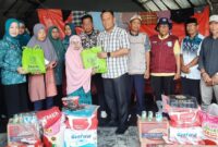 Pj Bupati Bone Andi Winarno Eka Putra (kemeja kotak-kotak) menyerahkan bantuan korban kebakaran di Tibojong, Minggu (1/9/2024). (ist)