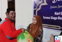 Ketua Tagana Dinas Sosial Sinjai, Saktiawan menyerahkan bantuan paket sembako. (Andi Irfan)