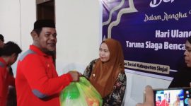 Ketua Tagana Dinas Sosial Sinjai, Saktiawan menyerahkan bantuan paket sembako. (Andi Irfan)