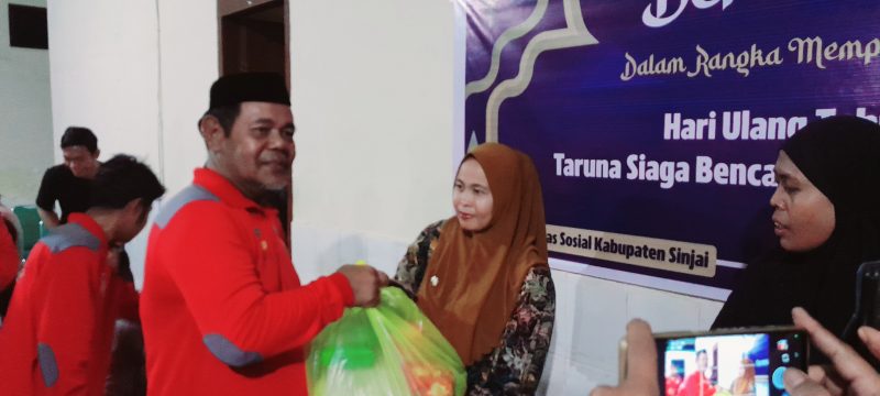 Ketua Tagana Dinas Sosial Sinjai, Saktiawan menyerahkan bantuan paket sembako. (Andi Irfan)