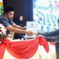 Ketua BK DPRD Kaltim Subandi, menyerahkan pengesahan kode etik dan tata beracara kepada Ketua DPRD Kaltim, Hasanudin Mas'ud. (Foto/Hms)