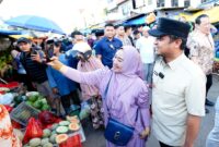 Momen hangat terjadi saat sejumlah warga dan pengunjung pasar berkesempatan mengabadikan foto bersama Gubernur Sulawesi Selatan, Andi Sudirman Sulaiman, di Pasar Terong, Kota Makassar, Jumat (20/2/2026).